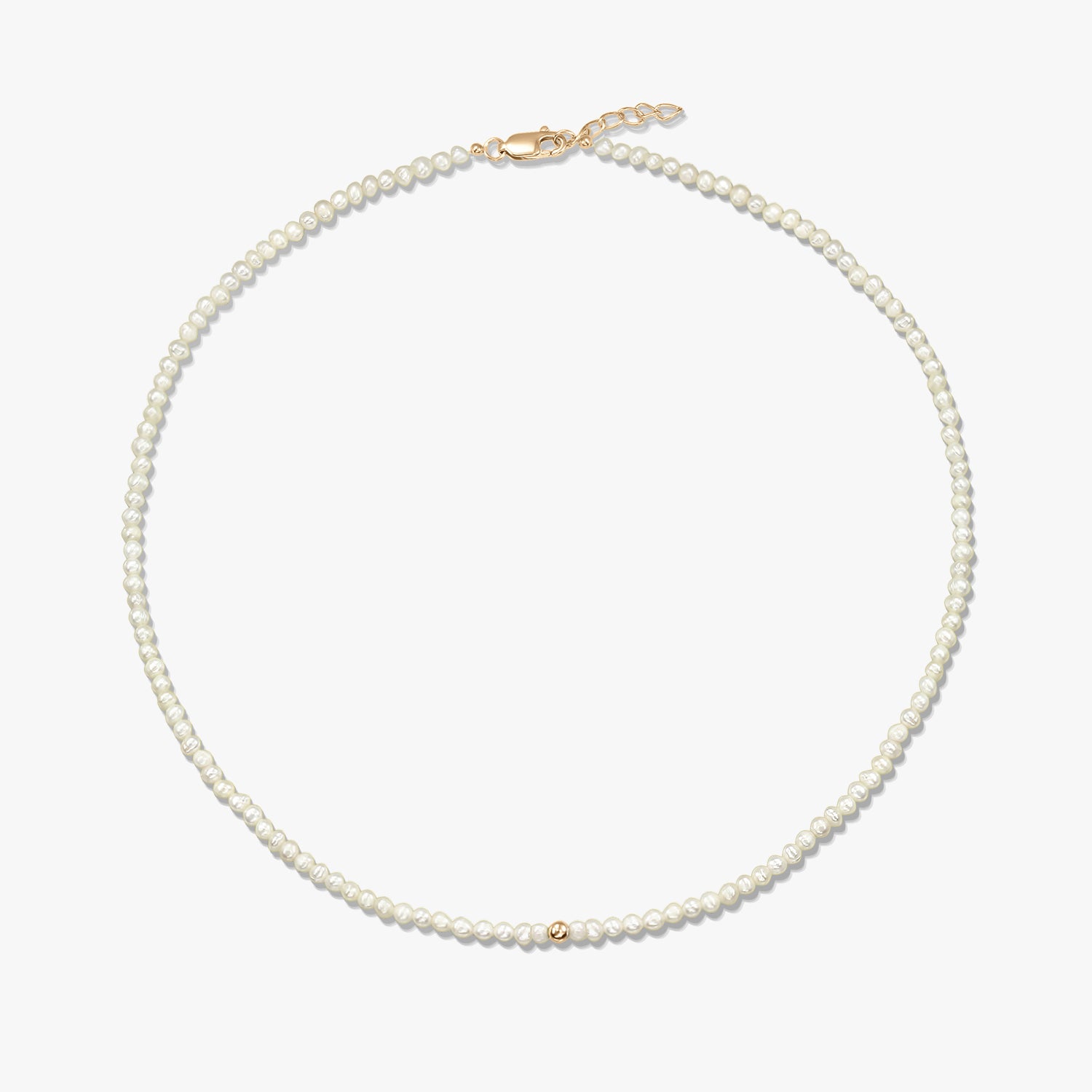 Square product image of a delicate natural pearl beaded necklace with a small 14K yellow gold bead accent and a yellow-gold lobster clasp with short extender, on a white background.