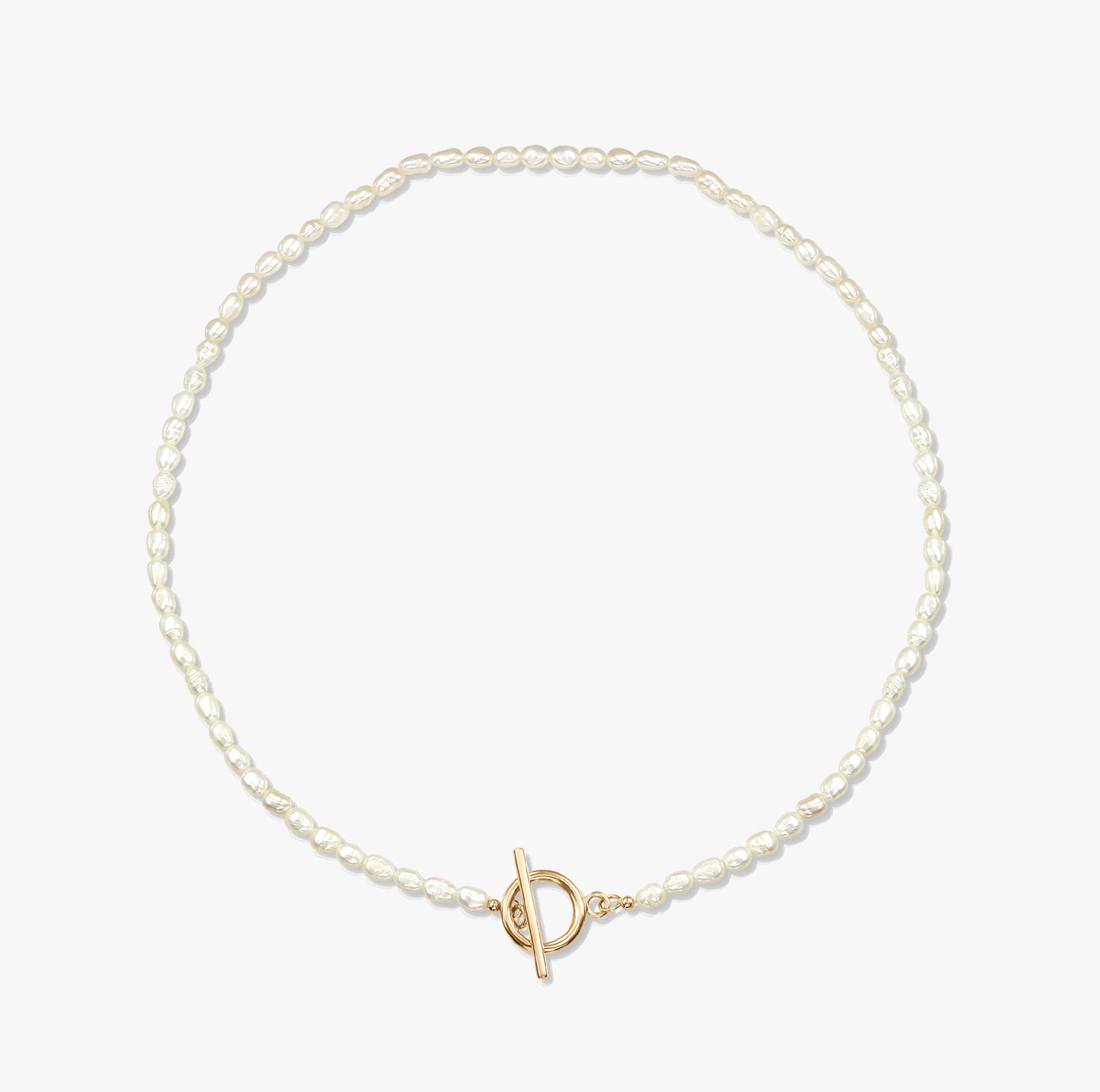 Minimalistický perlový náhrdelník se zlatou sponou na bílém pozadí.