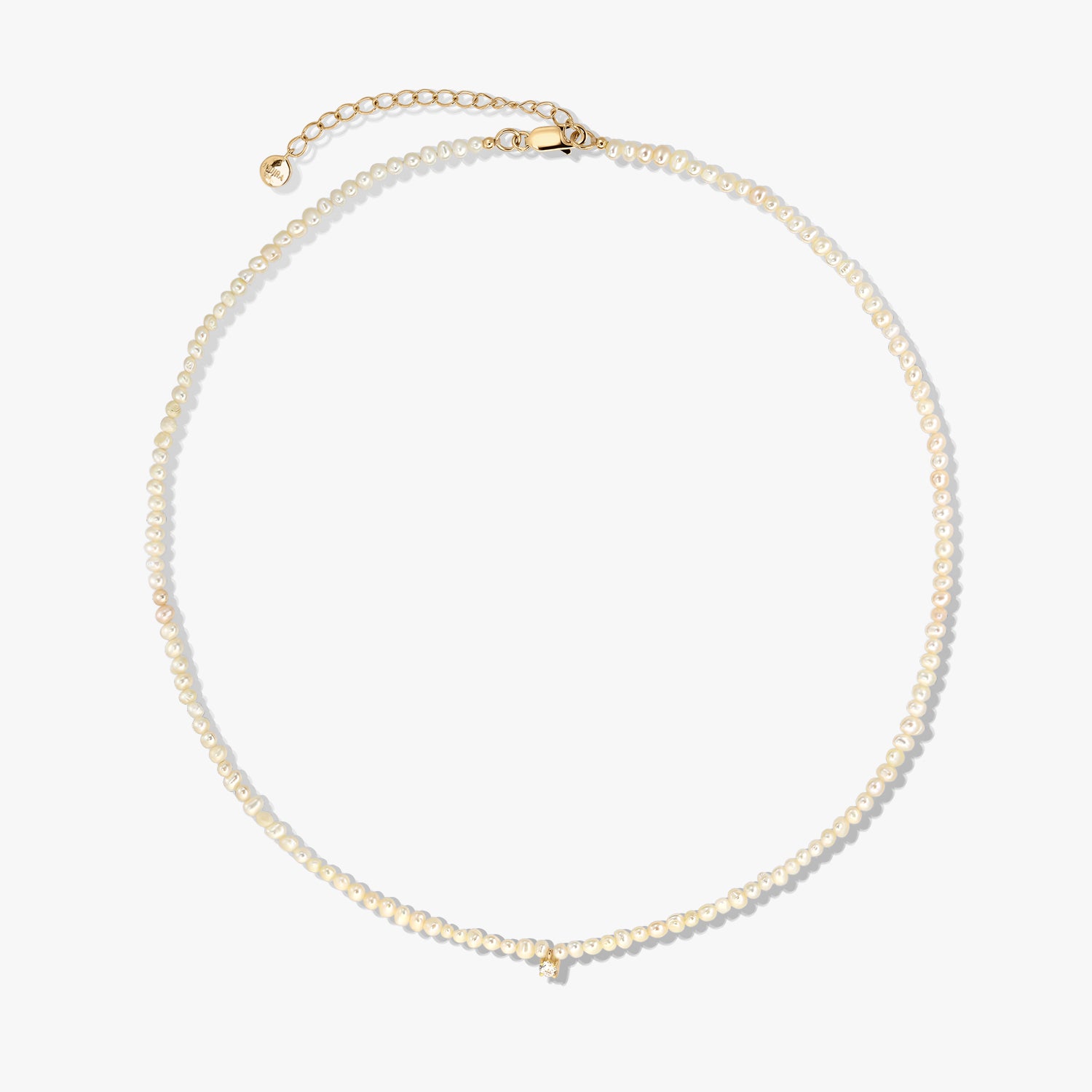 Delicate cultured pearl beaded necklace with a gold-plated sterling silver clasp and extender, photographed on a white background.