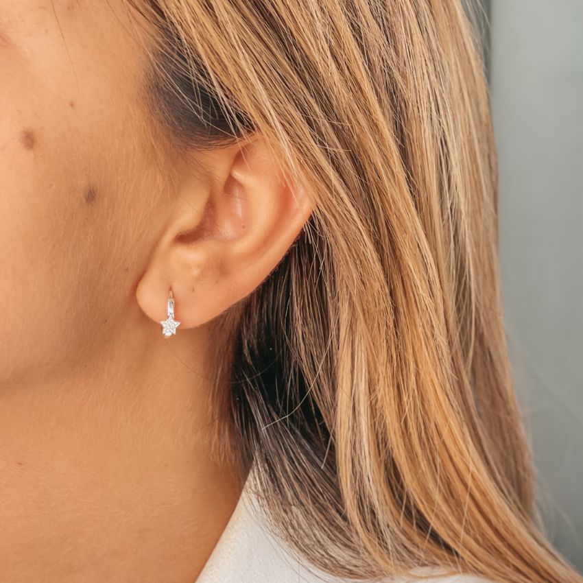 Close-up view of a silver earring with star-shaped zirconia