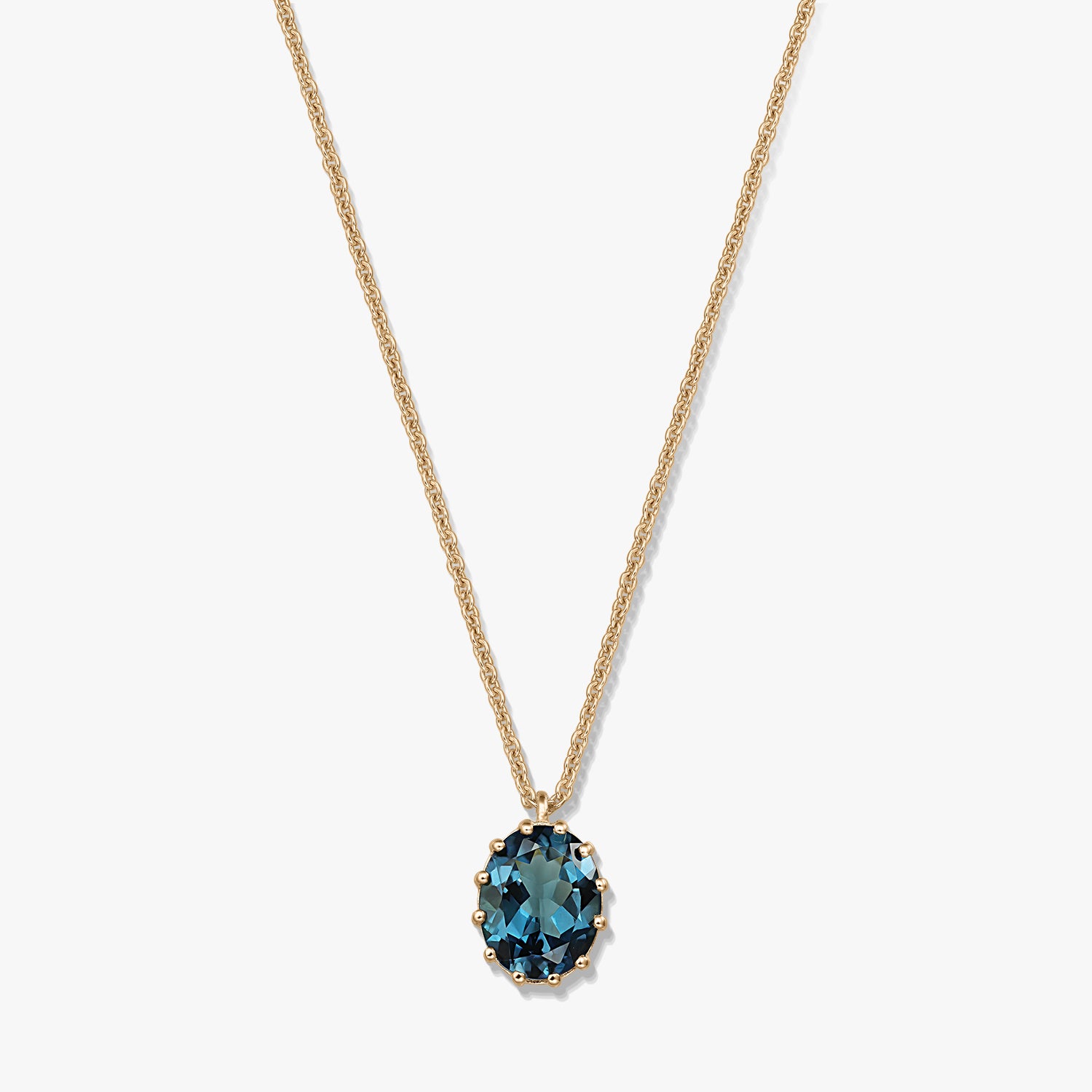 Delicate gold‑plated sterling silver necklace with an oval London blue topaz pendant on a white background.
