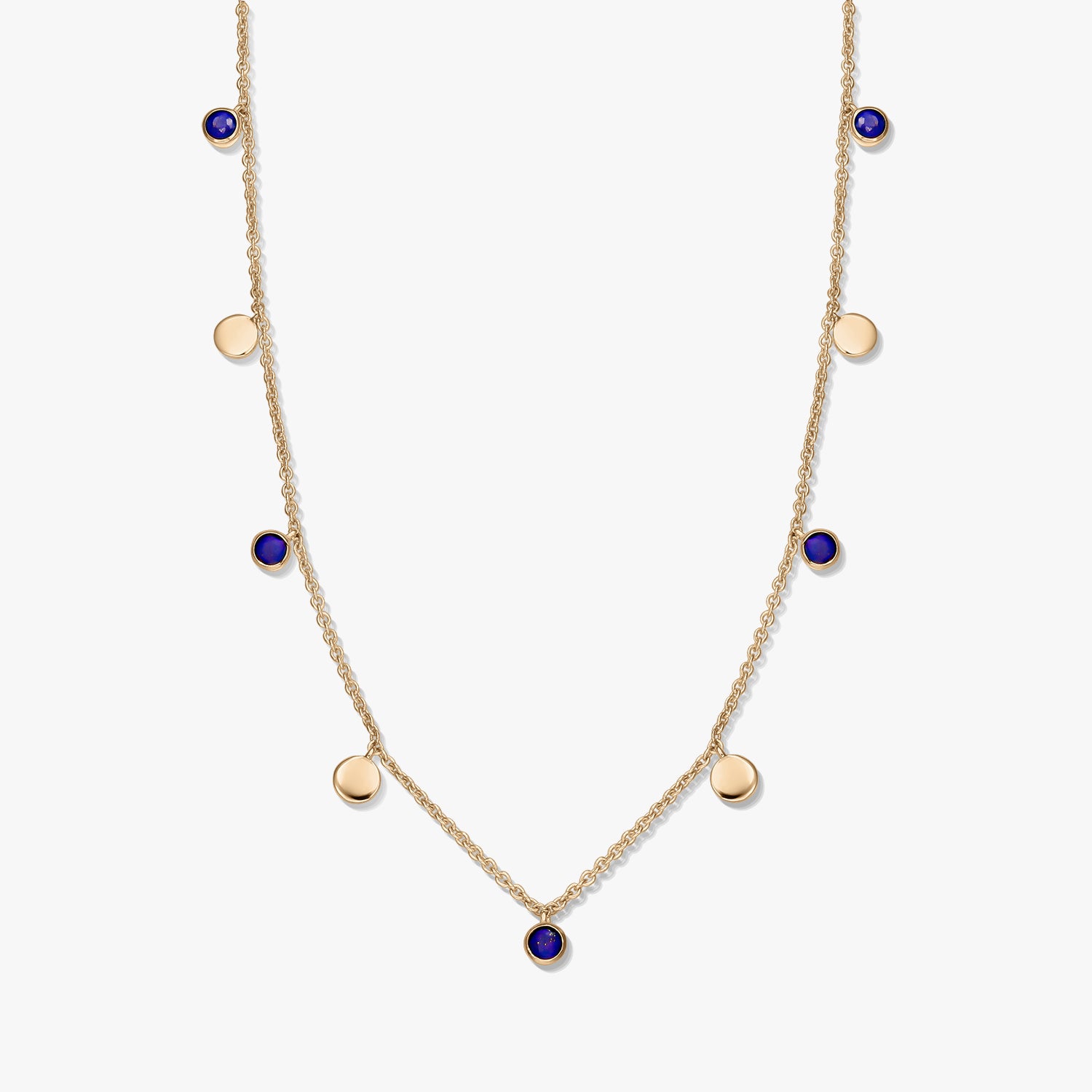 Gold‑plated sterling silver station necklace with round lapis lazuli cabochons and small gold disc charms on a delicate chain, photographed on a white background.