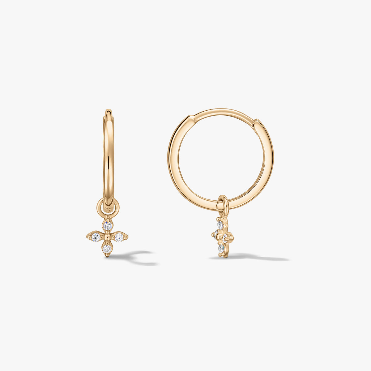 Pair of 14K yellow gold hoop earrings with small zirconia‑studded four‑petal flower charms on a white background.