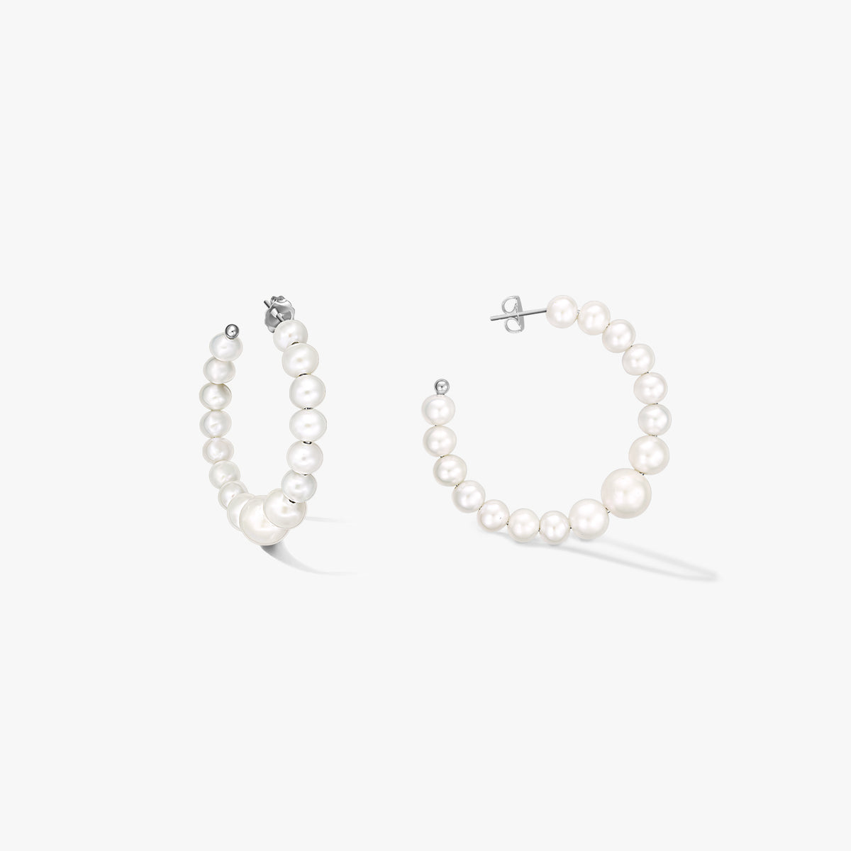 Pair of sterling-silver hoop earrings strung with graduated natural white pearls, shown on a white background.