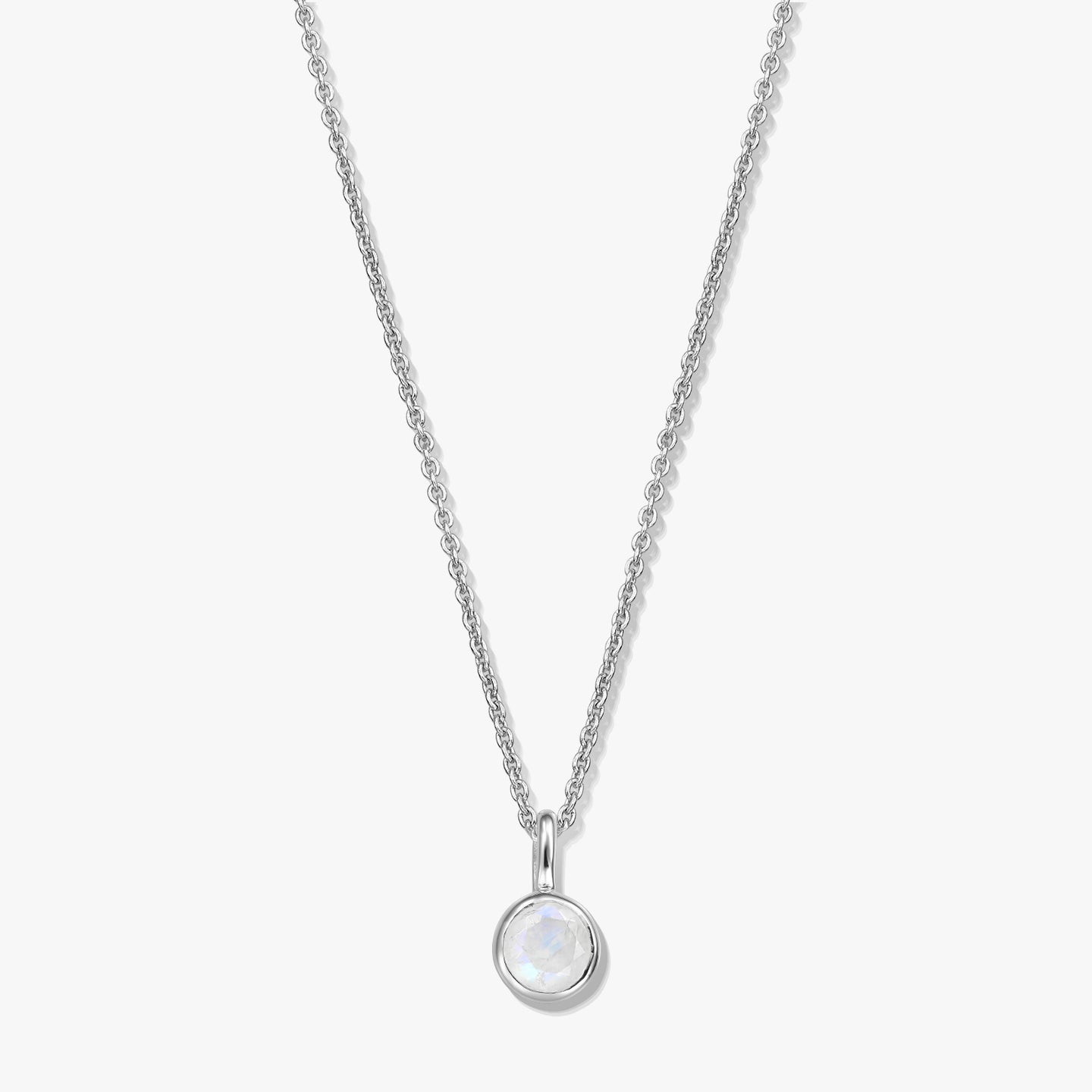 Sterling silver birthstone necklace with a round bezel-set moonstone pendant on a fine chain, photographed on a white background.