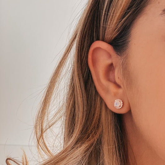 Close-up of a person's ear wearing a Keira Rose Silver Earring with Moonstone on a light background.