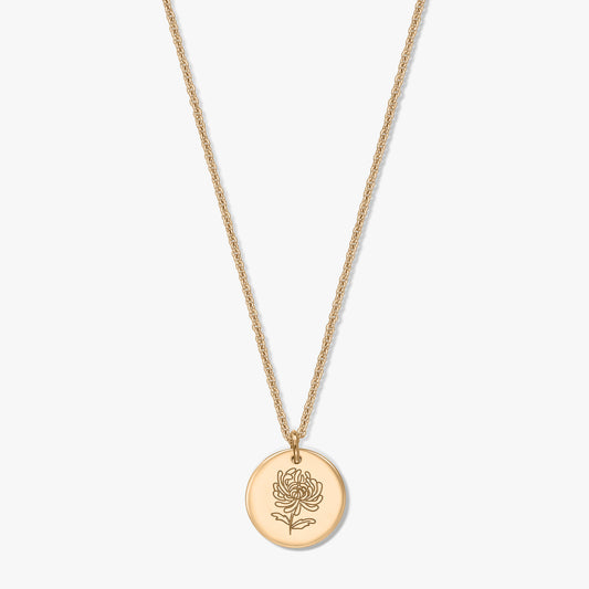 Gold-plated silver necklace with a round coin pendant engraved with a chrysanthemum, the November birthflower, on a white background.