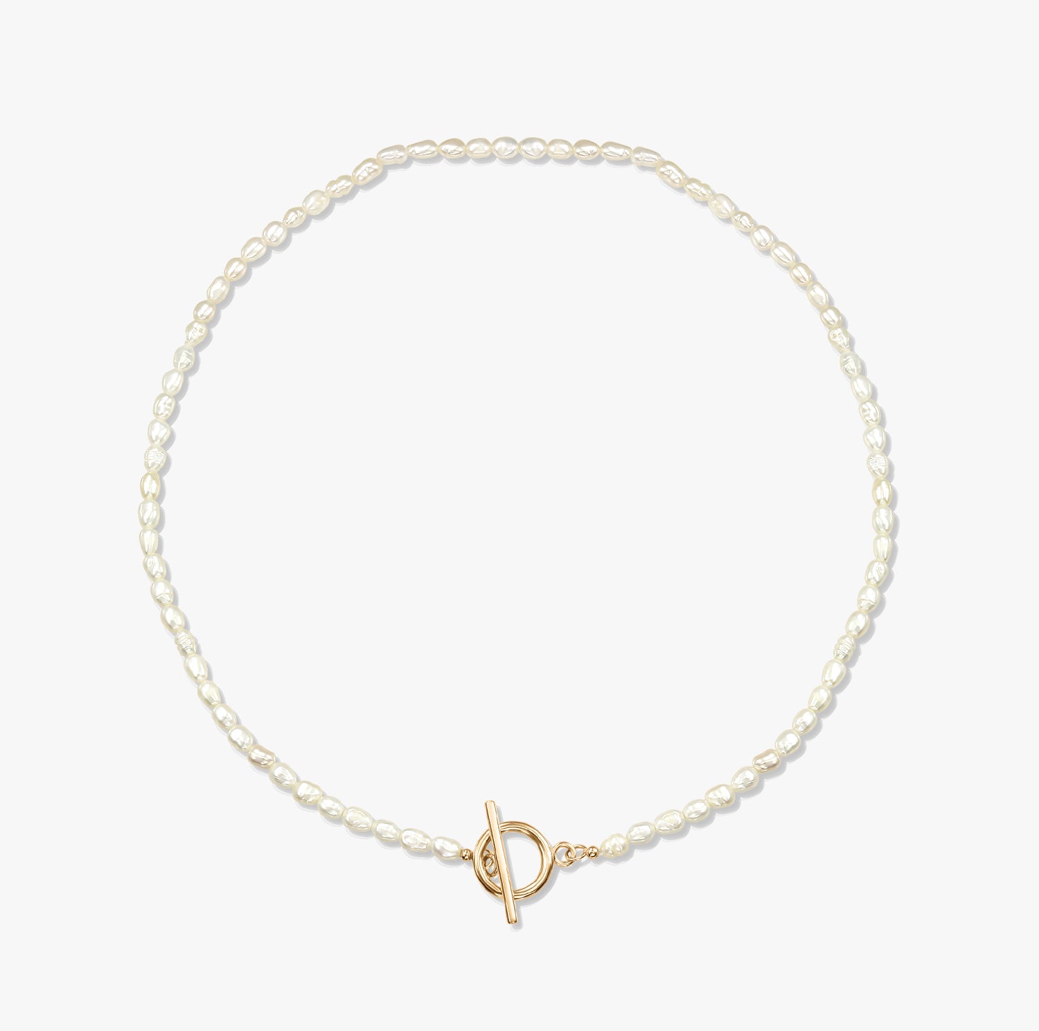 Minimalistický perlový náhrdelník se zlatou sponou na bílém pozadí.