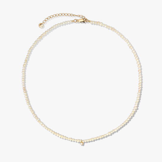 Delicate cultured pearl beaded necklace with a gold-plated sterling silver clasp and extender, photographed on a white background.