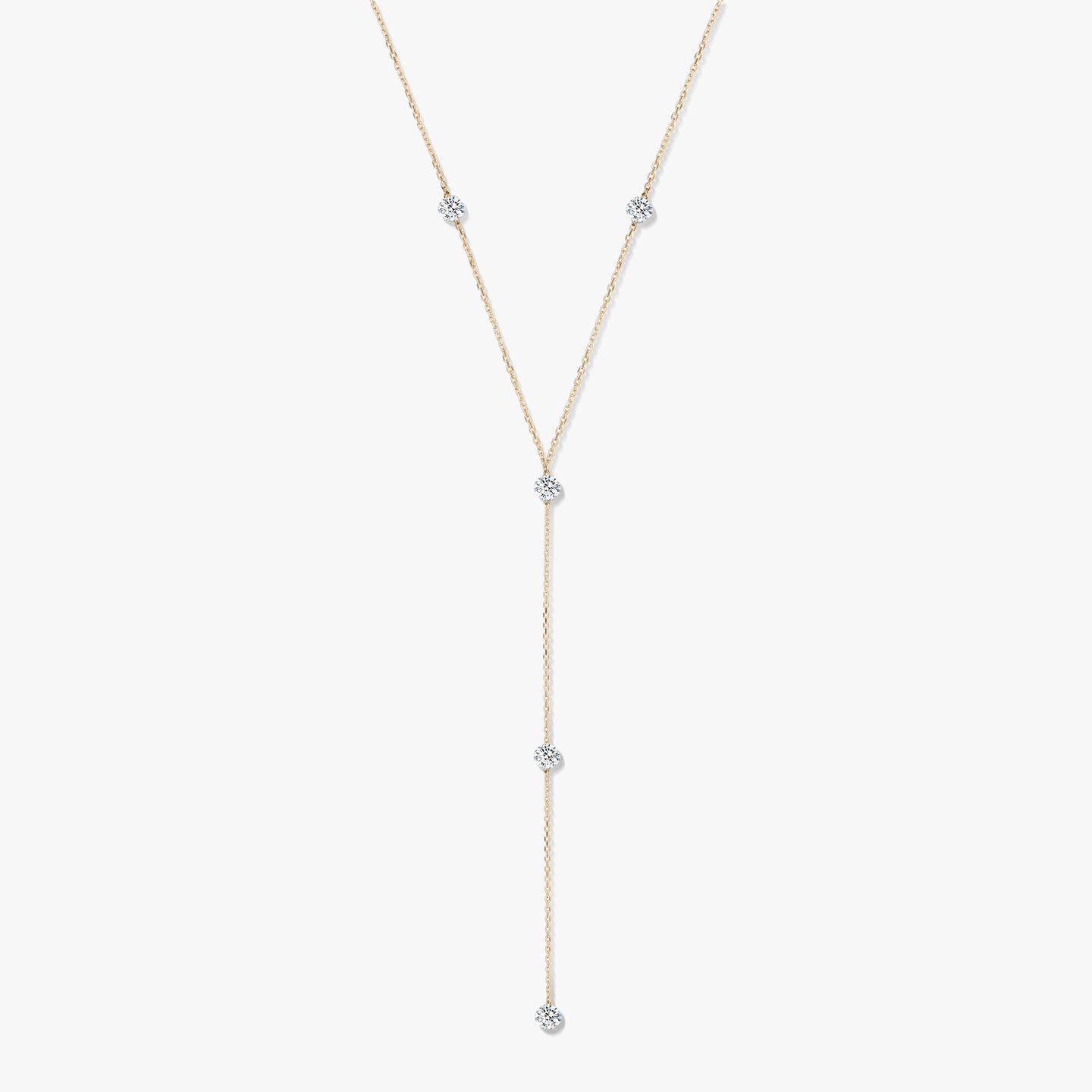 Náhrdelník typu lariat ze žlutého zlata 14K s pěti kulatými diamanty v rámečkovém zasazení na bílém pozadí.