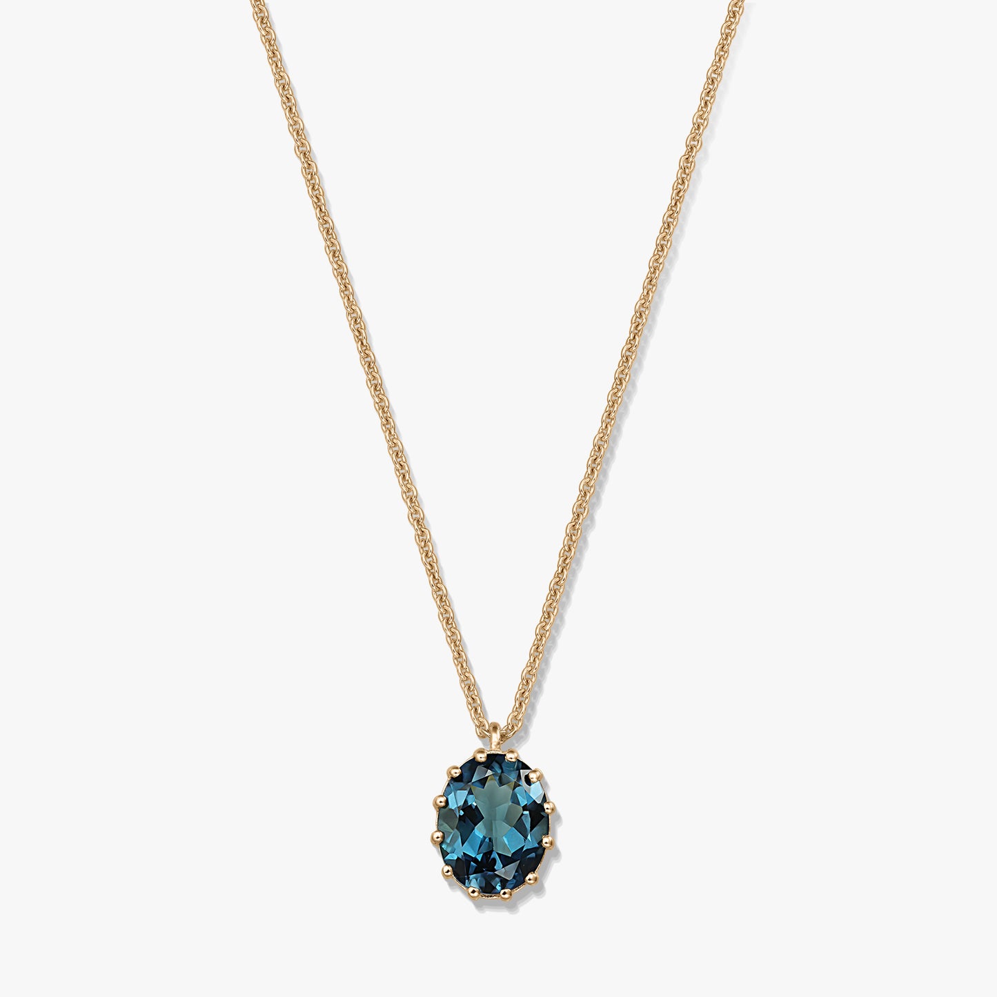 Delicate gold‑plated sterling silver necklace with an oval London blue topaz pendant on a white background.