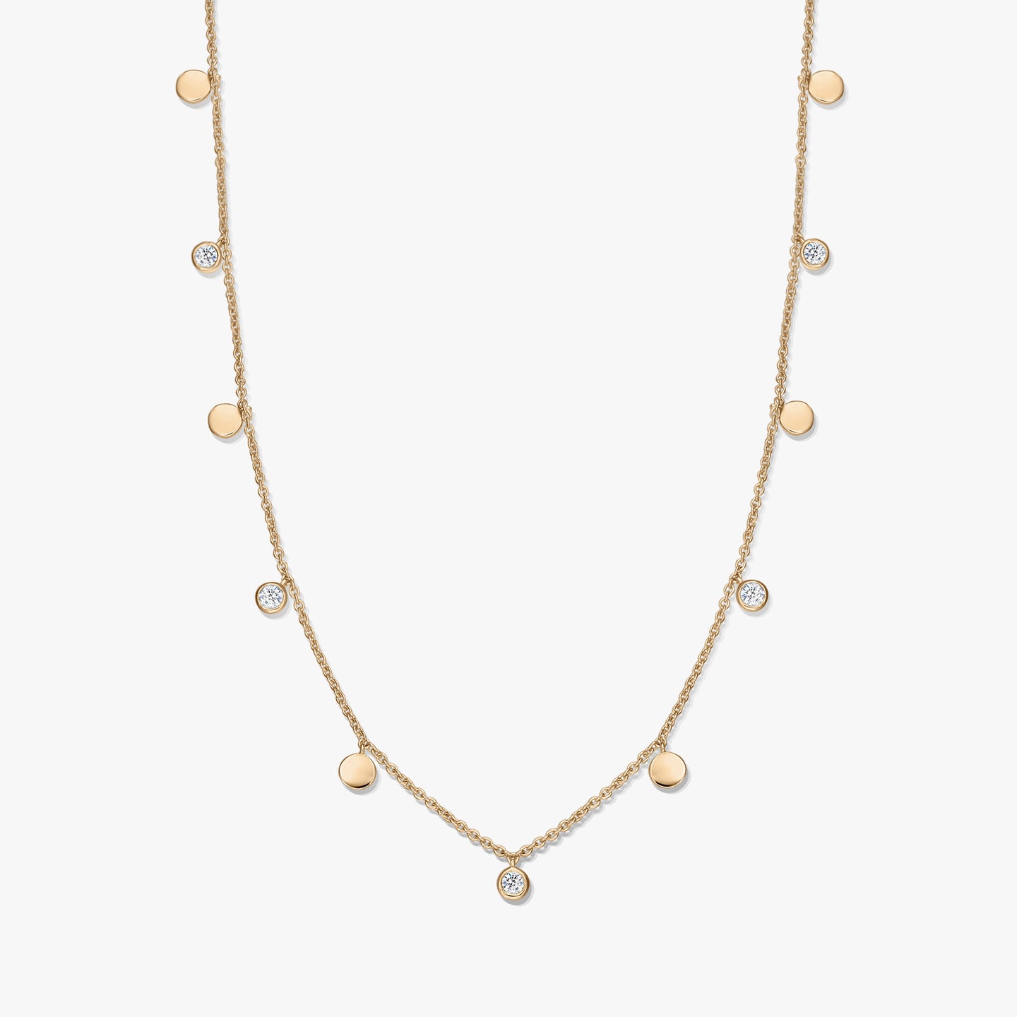Gold‑plated sterling silver station necklace with alternating small polished disc charms and bezel‑set white topaz on a delicate chain, photographed on a white background.