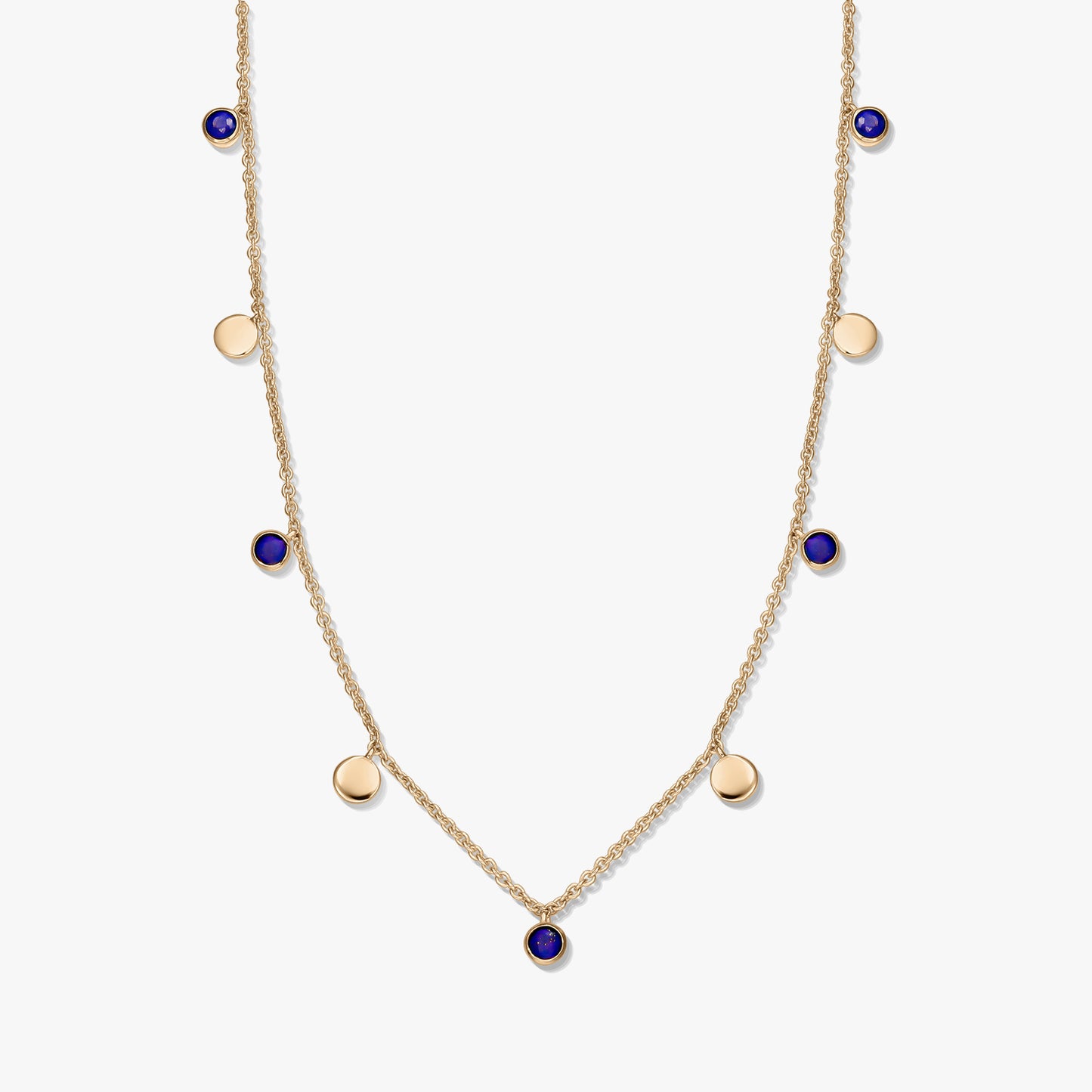Gold‑plated sterling silver station necklace with round lapis lazuli cabochons and small gold disc charms on a delicate chain, photographed on a white background.