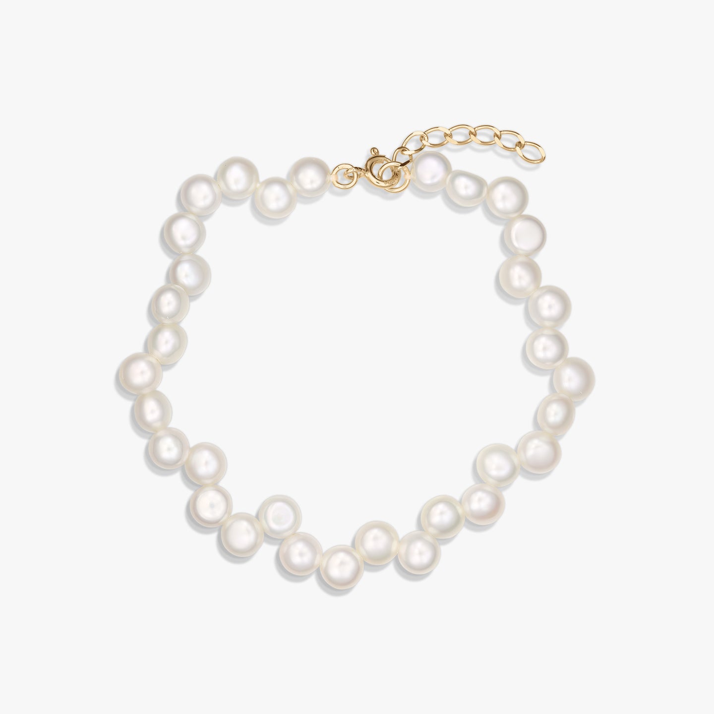 Gold‑plated 925 silver bracelet strung with natural white pearls and an adjustable extender chain, photographed on a white background.