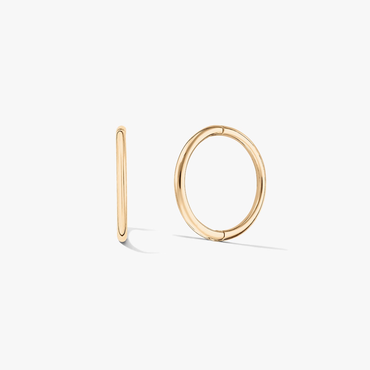 Pair of small yellow-gold hoop earrings on a white background, one shown front-facing and one in side profile.