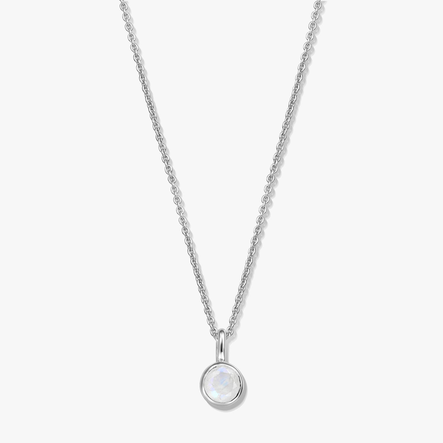 Sterling silver birthstone necklace with a round bezel-set moonstone pendant on a fine chain, photographed on a white background.