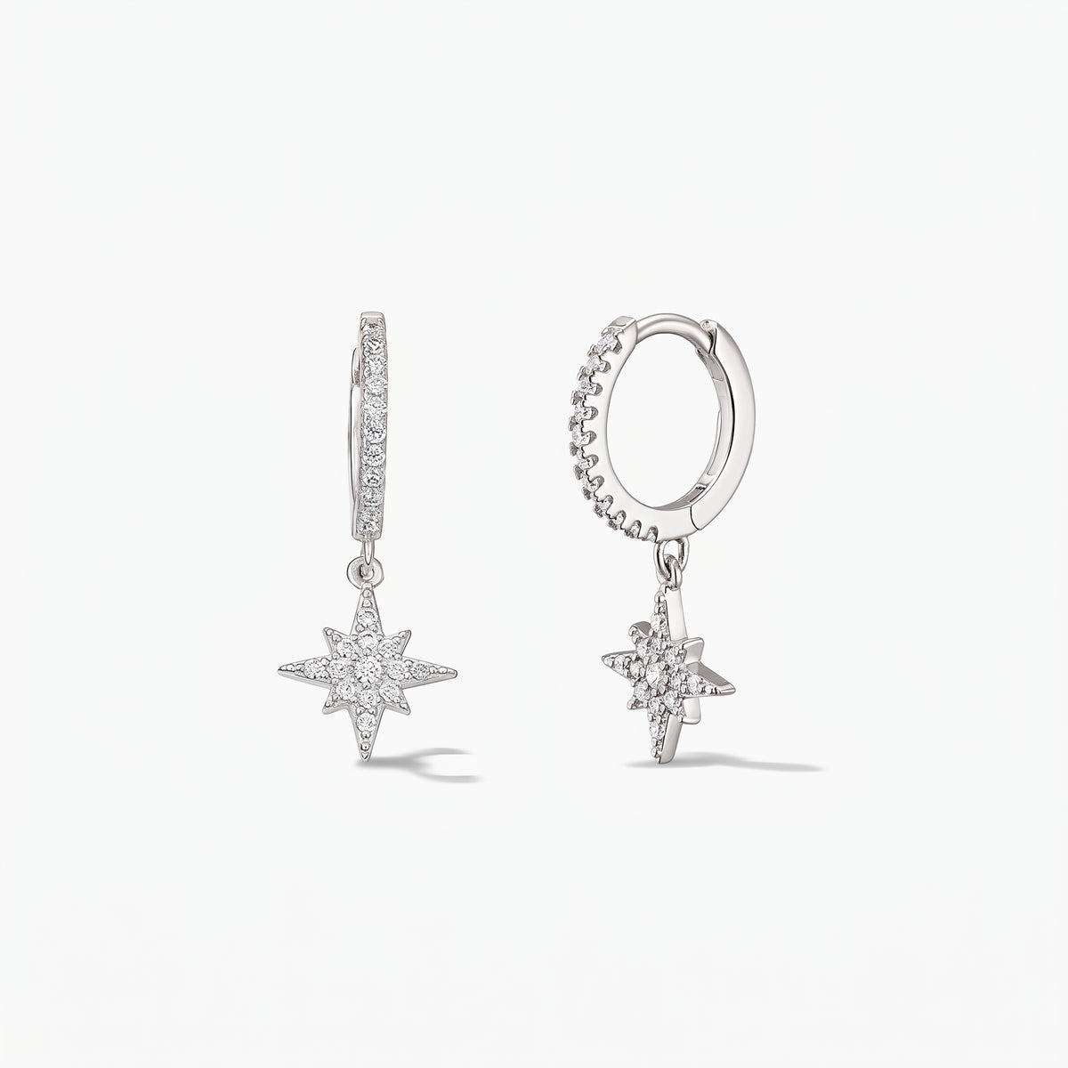 Pair of 925 sterling-silver huggie hoop earrings with pavé white zirconia North Star charms on a white background.