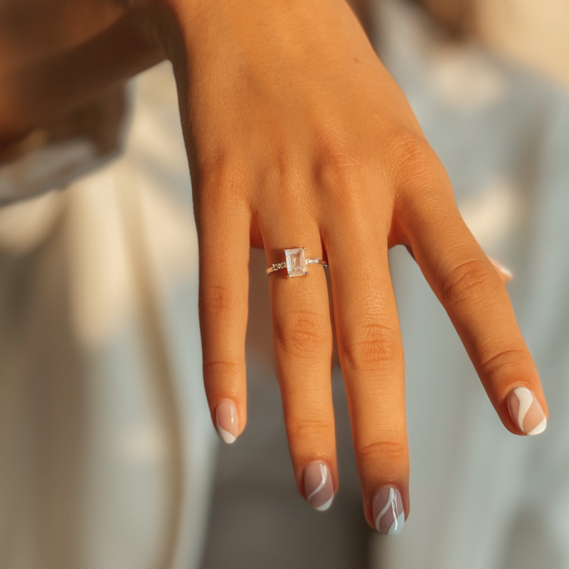 Ruka s prstenem Evie Silver s měsíčním kamenem a moderním designem nehtů.