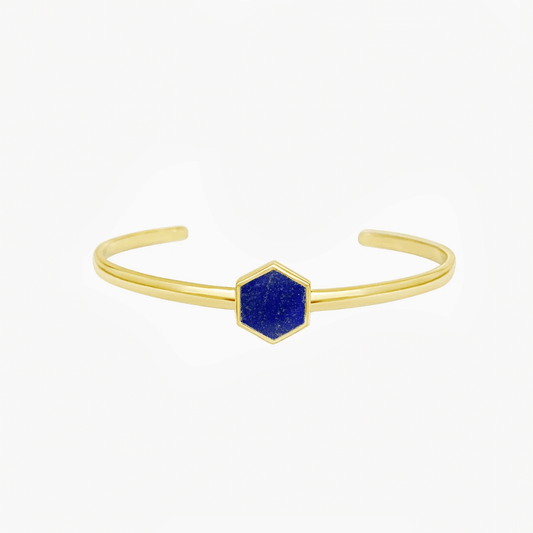 Stříbrný náramek se zlatým nádechem s šestihranným modrým středovým kamenem lapis lazuli na bílém pozadí.