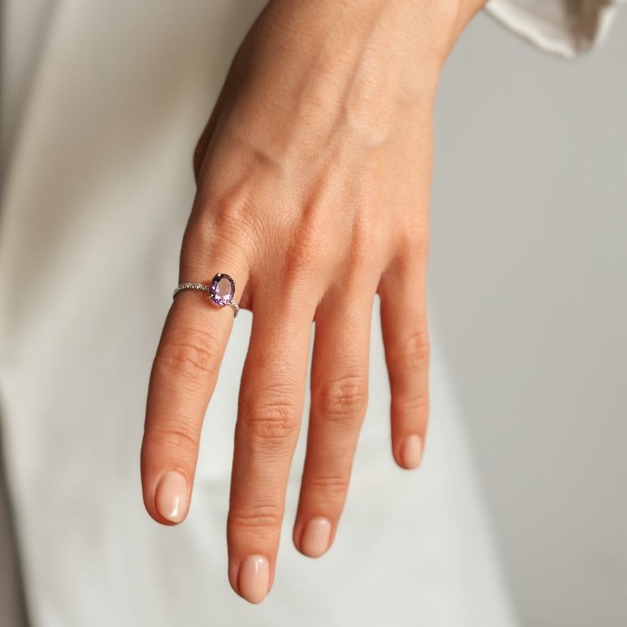A close-up of a hand wearing a Reina Silver Ring with Amethyst and Zirconia