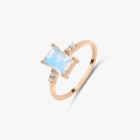 Rose gold silver ring with a moonstone and zirconia stones on a white background.